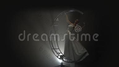 <strong>艺术体操</strong>女孩在建筑月亮上穿着裙子旋转。烟雾背景。慢动作